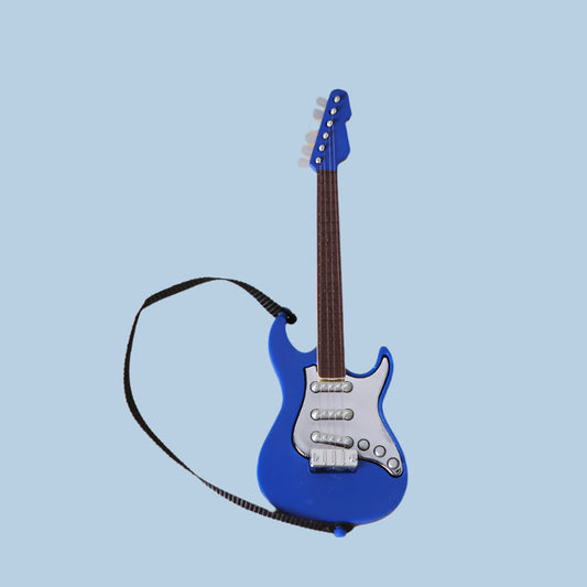 Blue toy guitar with a strap on a blue background