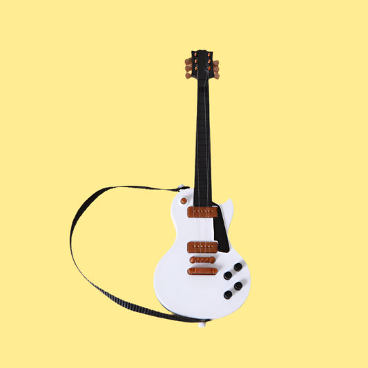 White toy guitar with brown details on a beige background.
