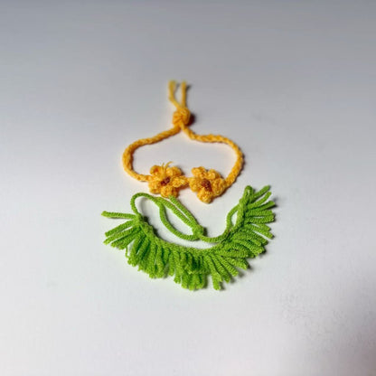 Green and yellow crocheted necklace on a white background